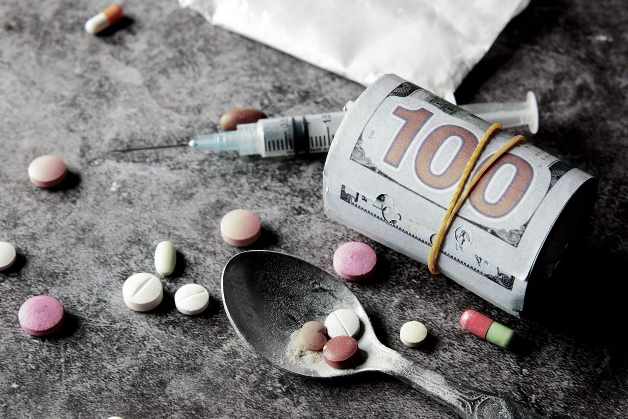 A roll of cash sits beside narcotics, a reminder of the financial scale of the trafficking trade.